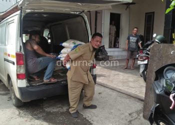 Seorang petugas mengangkut beras BPNT.