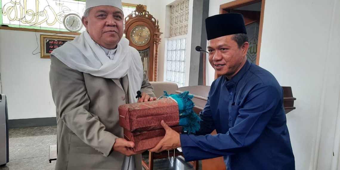 Bupati Bandung terpilih HM Dadang Supriatna menyerahkan cindera mata kepada Pimpinan Ponpes Darul Ma'arif KH Sofyan Yahya, di Desa Rahayu, Kec Margaasih, Kab Bandung, Jumat (12/2/2021).