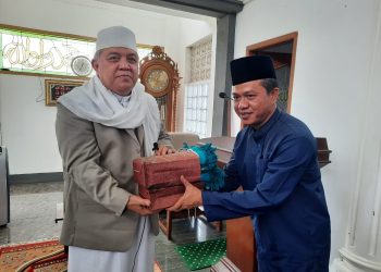 Bupati Bandung terpilih HM Dadang Supriatna menyerahkan cindera mata kepada Pimpinan Ponpes Darul Ma'arif KH Sofyan Yahya, di Desa Rahayu, Kec Margaasih, Kab Bandung, Jumat (12/2/2021).