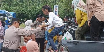 Anggota Polri Bantu Angkut Warga Ke Lokasi Obyek Wisata
