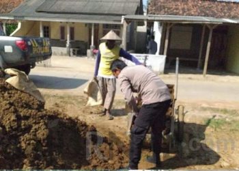 Polisi Bantu Pengurugan Di Bahu Jalan Desa Sabajaya