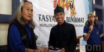 Ketua PWI Kabupaten Bandung H. Rahmat Sudarmaji menyerahkan kue kepada Kadiskominfo Yudi Abdurohman. (Sopandi/ dejurnal.com).