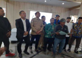 Pria pengantar paket (bertopi dan pegang map), sedang membacakan permintaan kepada DPRD Karawang. (Foto : Syarif Hidayat)