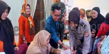 Polwan Bantu Tenaga Kesehatan Imunisasi Polio Pada Anak.