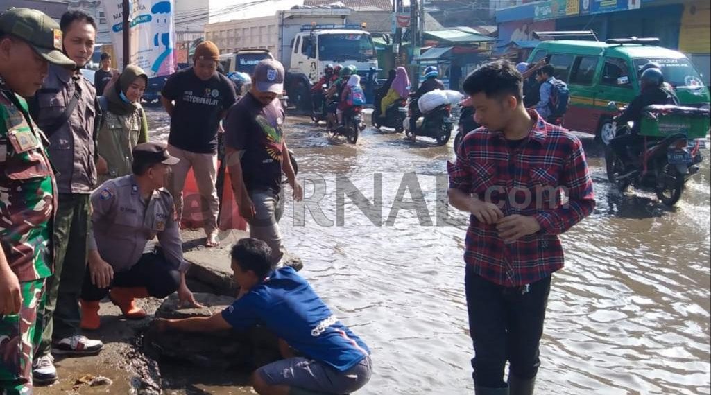 Sinergitas TNI – Polri, Bhabinkamtibmas Bersama Babinsa Bantu Warga Menyedot Genangan Air di Jalan Raya Dayeuhkolot