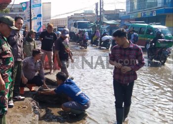 Sinergitas TNI – Polri, Bhabinkamtibmas Bersama Babinsa Bantu Warga Menyedot Genangan Air di Jalan Raya Dayeuhkolot