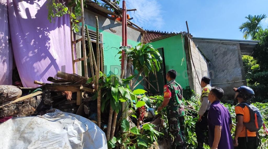 Rumah Warga Alami Kerusakan Akibat Tertimpa Pohon Tumbang, Bhabinkamtibmas Lakukan Penanganan