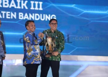 Kepala Badan Perencanaan Pembangunan, Riset, dan Inovasi Daerah (Bapperida) Kabupaten Bandung, Erwin Rinaldi saat menerima trofi penghargaan.