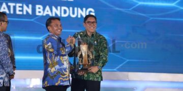 Kepala Badan Perencanaan Pembangunan, Riset, dan Inovasi Daerah (Bapperida) Kabupaten Bandung, Erwin Rinaldi saat menerima trofi penghargaan.